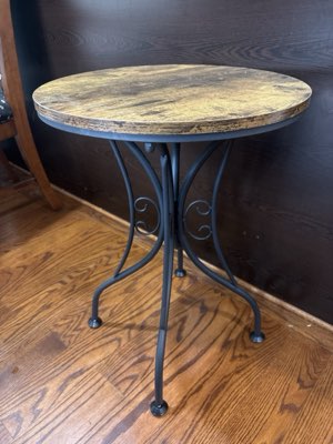 Round side table, wooden top on a black scrolled metal base