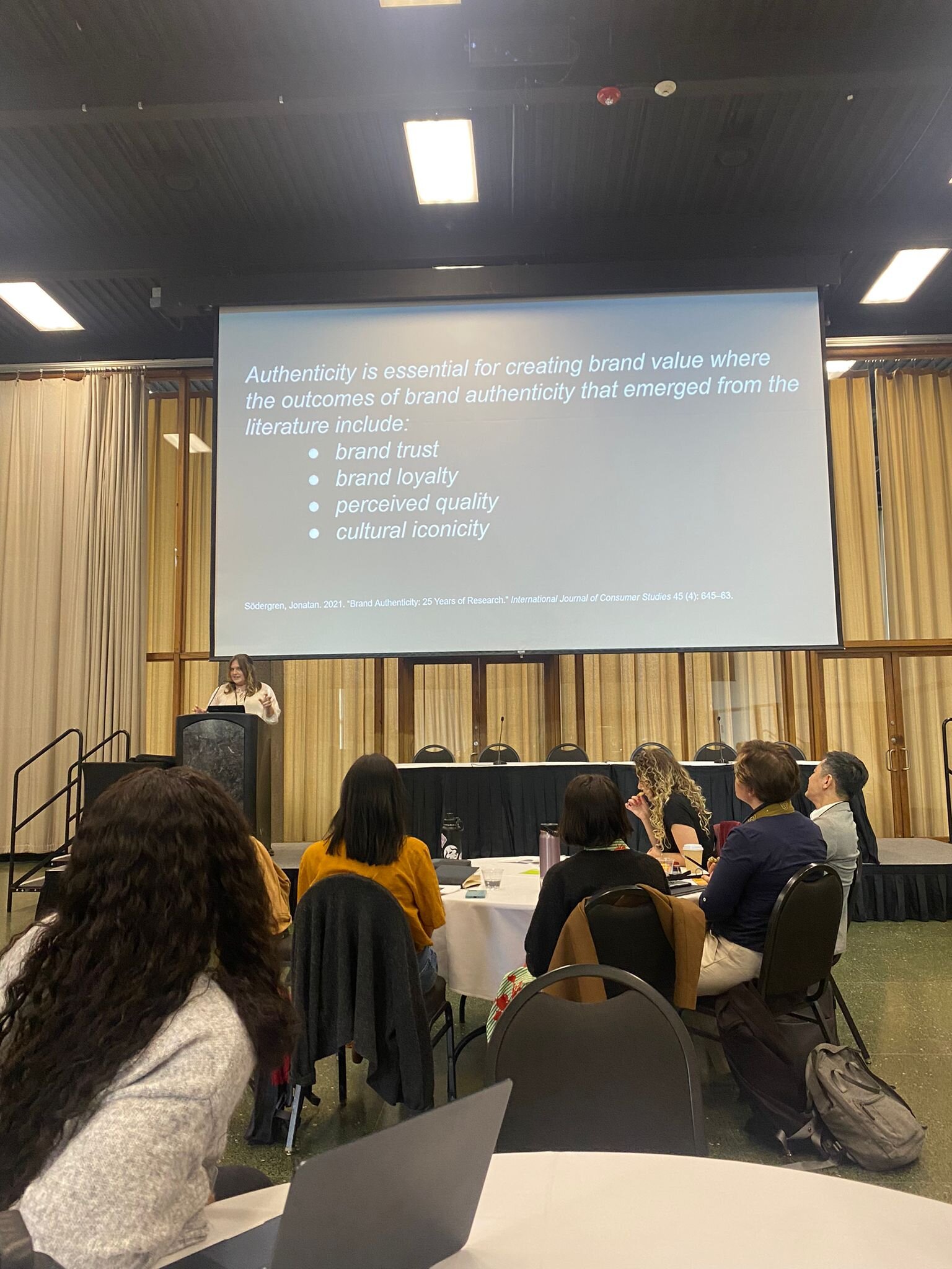 Conference slide: brand authenticity outcomes from the literature — brand trust, brand loyalty, perceived quality, cultural iconicity